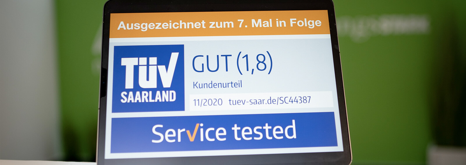 Darstellung des TÜV Siegels mit der Note "gut" auf einem Tabletdisplay.