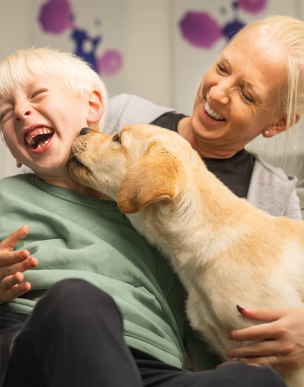 Mutter und Kind mit Hund glücklich