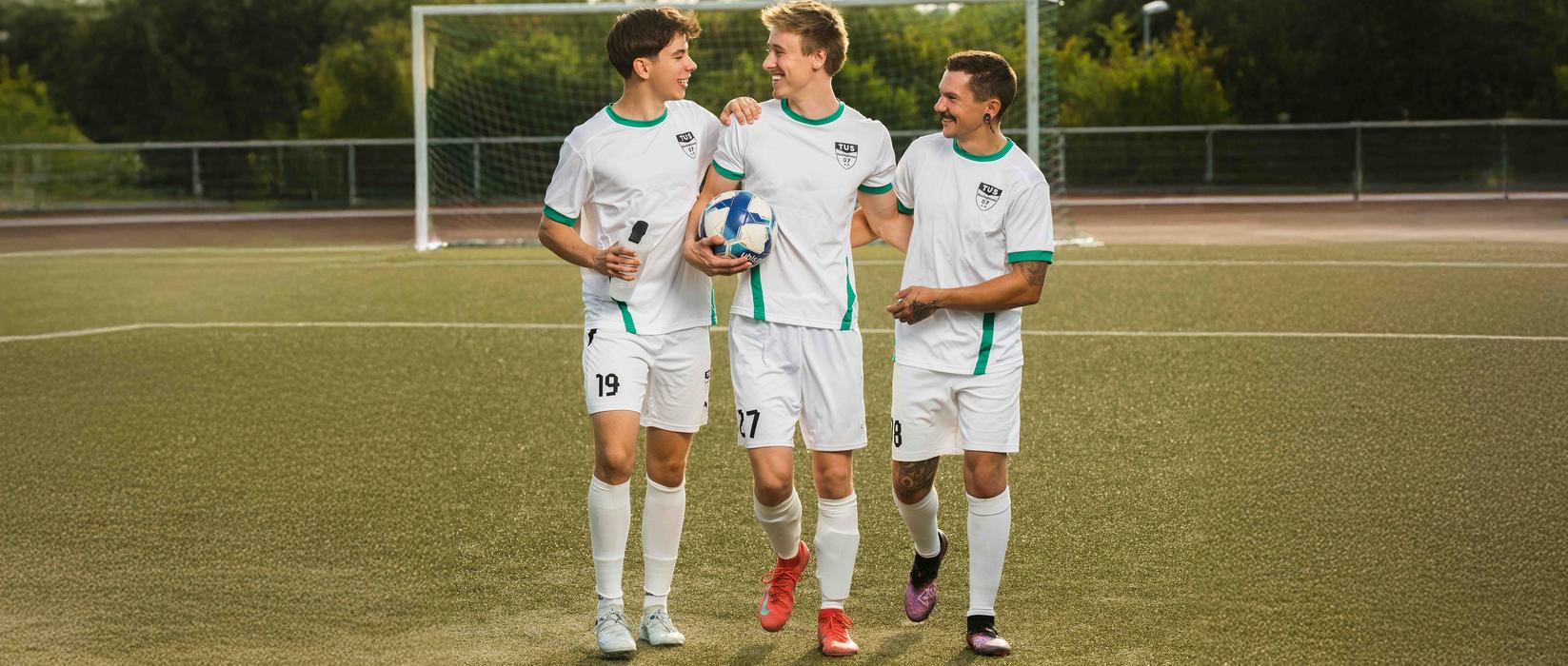 Drei Jungs spielen Fussball im Verein