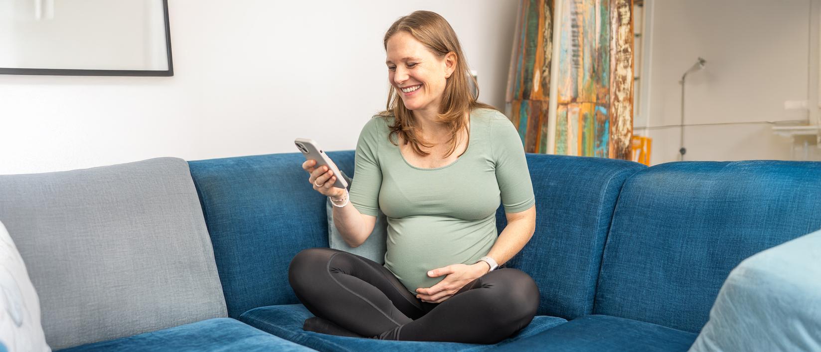 Schwangere Frau am Handy